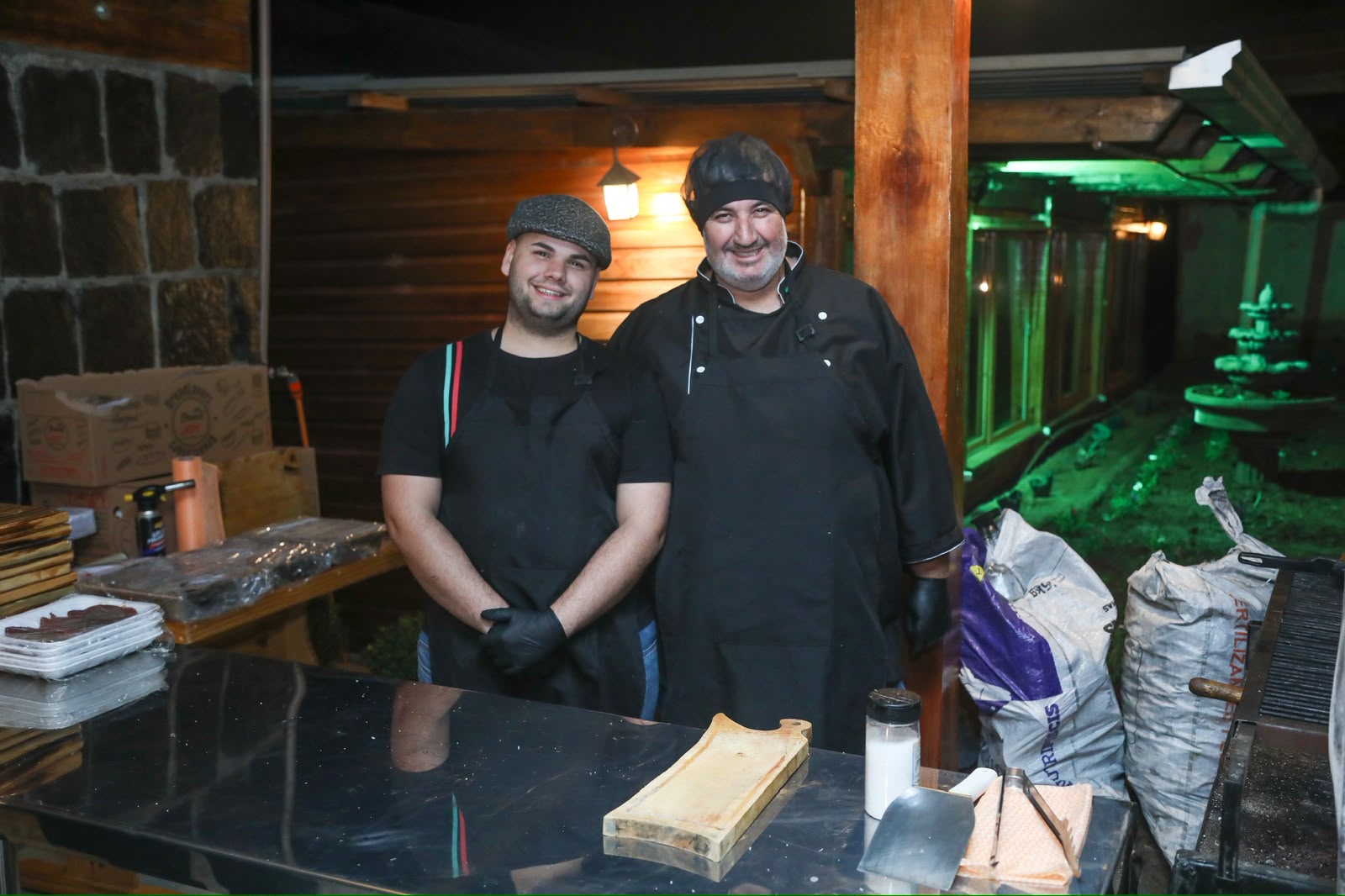 Equipe do Gordinho sorrindo atrás do balcão, ao lado da churrasqueira
