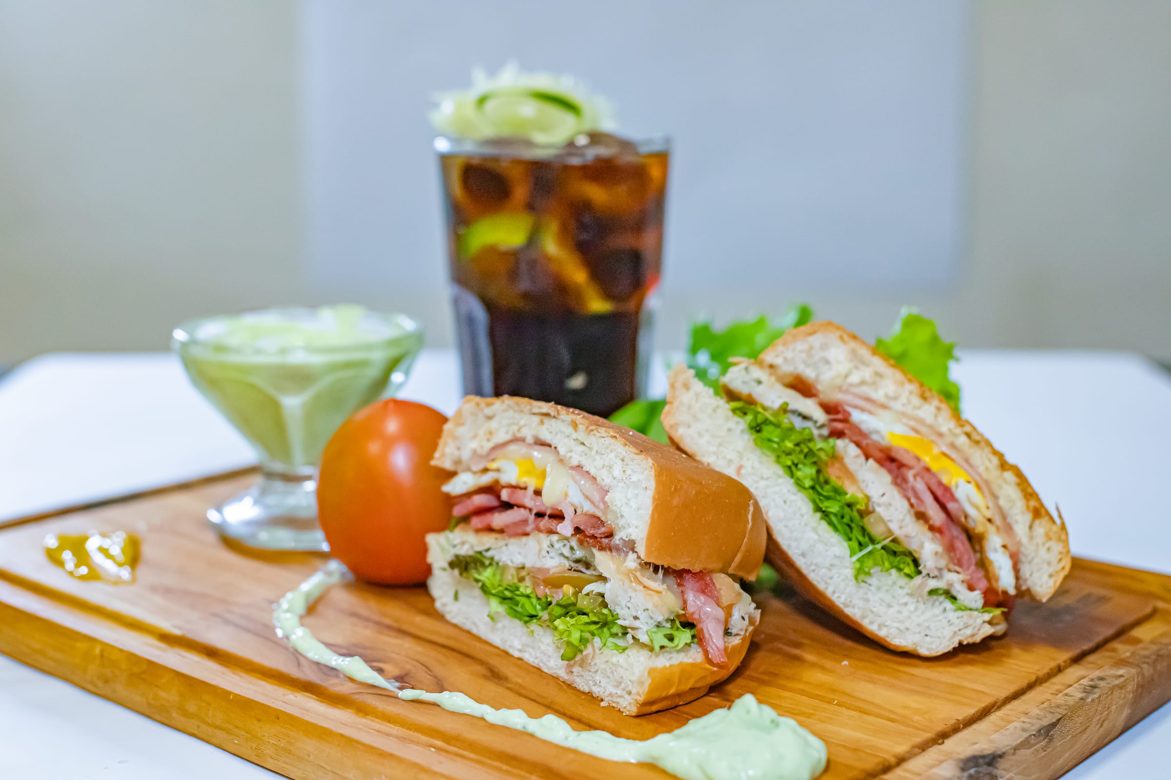 Lanche na tábua acompanhado de molho e refrigerante gelado